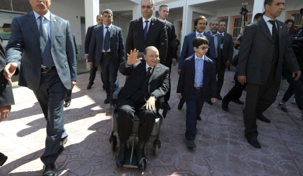 President Abdelaziz Bouteflika (C, in a wheelchair) waving as he leaves after voting in the presidential elections in Algiers, on April 17, 2014 (AP Photo/Sidali Djarboub, File)