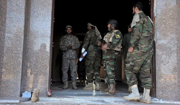 Libyan soldiers stand at the entrance of a damaged empty building that was used by Islamic militias during heavy clashes in Benghazi, Libya, on November 3, 2014 (AP Photo/Mohammed El-Sheikhy)