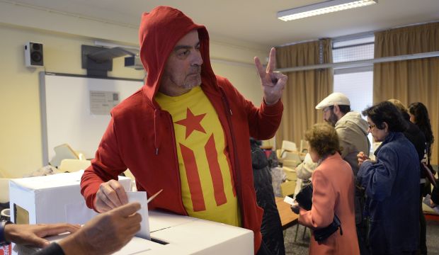 A man with the Estelada flag on his T-shirt (pro-independence Catalan flag) makes the victory sign as he casts his vote in a polling station for an informal poll for the independence of Catalonia in Barcelona, on November 9, 2014, Spain. (AP Photo/Manu Fernandez)