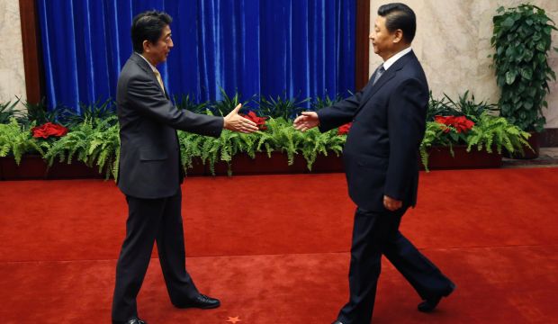Japan's Prime Minister Shinzo Abe, left, and China's President Xi Jinping, right, shake hands during their meeting at the Great Hall of the People, on the sidelines of the Asia Pacific Economic Cooperation (APEC) meetings, in Beijing, on November 10, 2014. (AP Photo/Kim Kyung-Hoon, Pool)