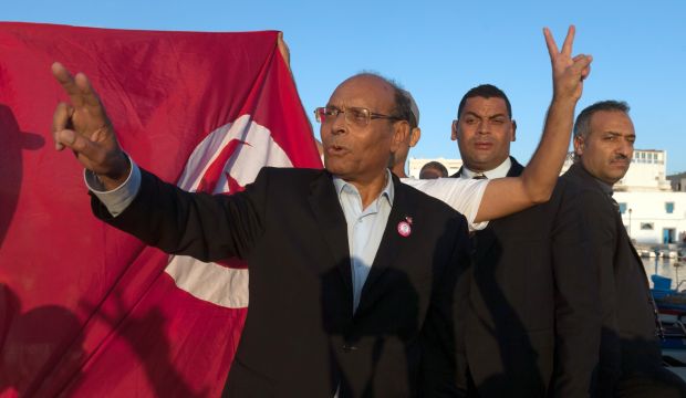 Presidential candidate and Tunisian president, Moncef Marzouki, waves before addressing his supporters during a campaign meeting in Bizerte, northern Tunisia, on November 19, 2014. (AP Photo/Aimen Zine)