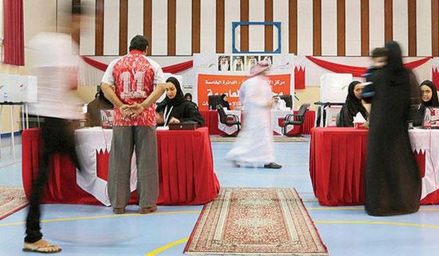 Election officials assist voters at a polling station in Manama, Bahrain, on Saturday, November 29, 2014. (AP Photo/Hasan Jamali)