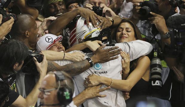 Mercedes driver Lewis Hamilton of Britain hugs his partner American singer Nicole Scherzinger after winning the Emirates Formula One Grand Prix to clinch the Formula One world championship at the Yas Marina racetrack in Abu Dhabi, United Arab Emirates. (AP)