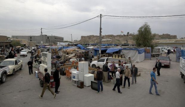 The Citadel of Erbil looms over a market where people shop for secondhand goods in downtown Erbil, 217 miles (350 kilometers) north of Baghdad, Iraq, Sunday, November 16, 2014. (AP Photos)
