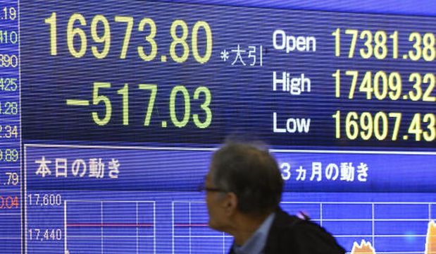 A man looks at the stock price board showing the Japan's benchmark Nikkei 225 index's huge dive of 517.03 points, or 2.96 percent to 16,973.80 Monday, November 17, 2014 in Tokyo. (AP Photos)