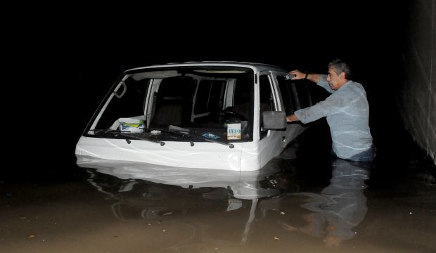 A Lebanese man stands next to his vehicle submerged in flooded water in the tunnel leading to Beirut's airport, on December 4, 2013. (STR/AFP/Getty Images)