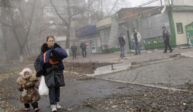 A Ukrainian woman and her daughter walk past a building that was damaged by overnight shelling in Donetsk, Ukraine, on November 7, 2014. (EPA/Alexander Ermochenko)
