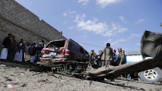Onlookers gather near a vehicle damaged by a car bomb attack on the residence of the Iranian ambassador in Sana', Yemen, on December 3, 2014. (Reuters/Khaled Abdullah)