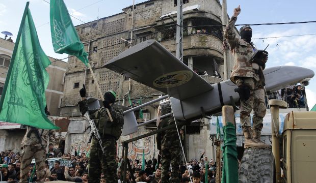 Palestinian fighters of the Ezz Al-Din Al Qassam militia, the military wing of Hamas, pose with weapons during a Hamas rally to commemorate the 27th anniversary of Hamas militant group in Gaza City, on 14 December 2014. (EPA/MOHAMMED SABER)