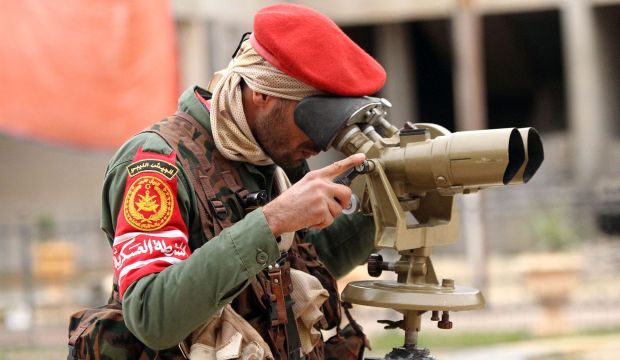 A member of the Libyan military police looks through binoculars as they fight alongside troops loyal to Khalifa Haftar, in clashes with Islamist gunmen in the eastern Libyan city of Benghazi, on December 16, 2014. (AFP Photo/Abdullah Doma)