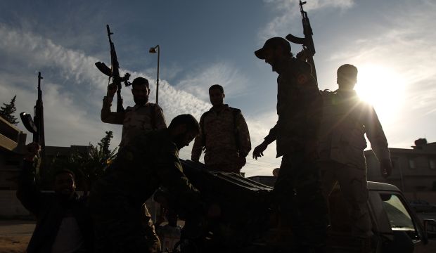 Members of a brigade loyal to Khalifa Haftar hold up their guns as they fight alongside Libyan army troops against Islamist gunmen in the eastern Libyan city of Benghazi on December 17, 2014. (AFP Photo/Abdullah Doma)