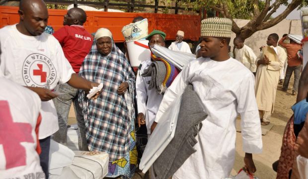 Red Cross workers distributes relief material to displaced victims of Boko Haram violence, at a relief camp in Dawaki, a local government area in Kano, December 16, 2014. (REUTERS/Stringer)