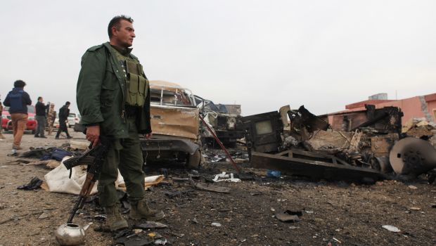 A member of the Kurdish forces stands in an area damaged by an improvised explosive device placed by Islamic State of Iraq and Syria militants that killed several Peshmerga fighters and injured dozens late Wednesday, when they pushed towards Sinjar Mountain. Thursday, Dec. 18, 2014. (AP Photos)