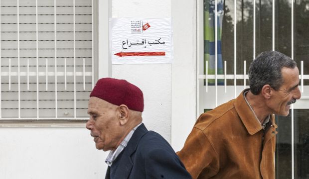 Tunisians walk past a polling station in Tunis, Tunisia, on December 21, 2014. (AP Photo/Ilyess Osmane)