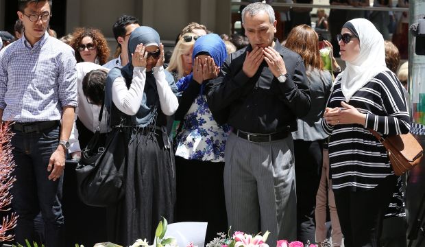 People pray and lay flowers near the Lindt Chocolat Cafe in Martin Place following a dramatic siege in Sydney, Australia, on December 16, 2014. (EPA/Nikki Short)