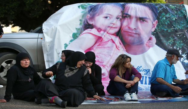 Families of Lebanese soldiers who are being held hostage by Islamist militants block a main road during a protest after Al-Nusra Front said it has killed policeman Ali Bazzal, in Lebanon, on December 6, 2014.  (AP Photo/Hussein Malla)