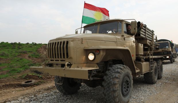 Iraqi Kurdish Peshmerga forces flash victory signs as they drive near the front lines in Zumar, Iraq, on December 19, 2014. (AP Photo/Zana Ahmed)