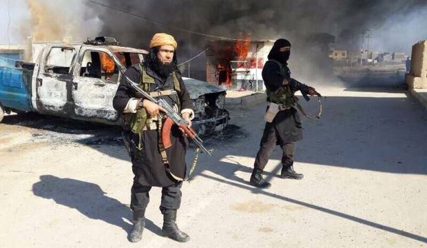 An image posted on a militant website shows Shakir Waheib, a senior member of ISIS, (L), next to a burning police vehicle in Iraq's Anbar Province. (AP Photo via militant website, File)