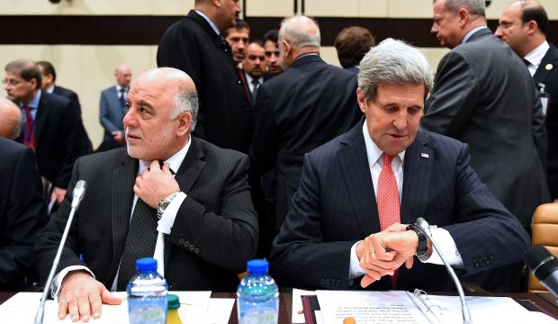 US Secretary of State John Kerry sits next to Iraqi Prime Minister Haider Al-Abadi during a high-level meeting of the 60-member coalition fighting ISIS, in Brussels, Belgium, on December 3, 2014. (AFP Photo/Emmanuel Dunand)