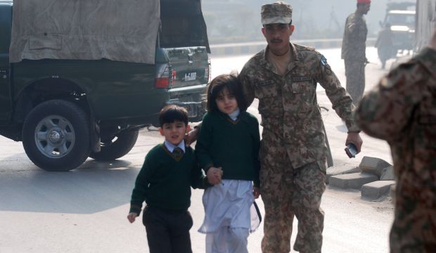 A soldier escorts schoolchildren from the Army Public School that was under attack by Taliban gunmen in Peshawar, Pakistan, on December 16, 2014. (Reuters/Khuram Parvez)