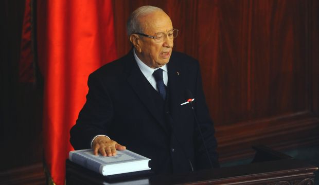 Beji Caid El-Sebsi puts his hand on the Qur'an to be sworn in as new Tunisian president during a ceremony at the National Assembly in Tunis, Tunisia, on December 31, 2014. (AP Photo/Hassene Dridi)