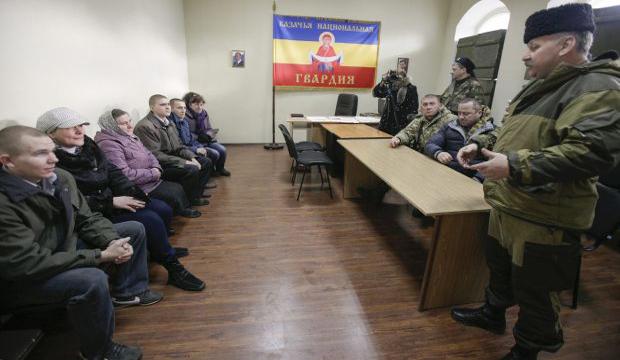 Pro-Russian rebels (L) hand Ukrainian prisoners of war to their mothers in Luhansk, Ukraine, 26 December 2014. (EPA/Yuriy Streltsov)