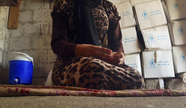 In this file photo taken Wednesday, Oct. 8, 2014, a 15-year-old Yazidi girl captured by the Islamic State group and forcibly married to a militant in Syria sits on the floor of a one-room house she now shares with her family after escaping in early August, while speaking in an interview with The Associated Press in Maqluba, a hamlet near the Kurdish city of Dahuk, 260 miles (430 kilometers) northwest of Baghdad, Iraq.  (AP Photo/Dalton Bennett)