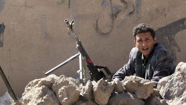 A member of the Shi'ite Houthi movement is seen next to a machine gun while securing the entrance to a ceremony commemorating the birth of Prophet Muhammad in Sana'a on January 3, 2015. (Reuters/Mohamed Al-Sayaghi)