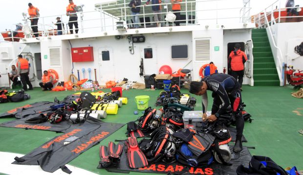 Indonesian divers prepare their equipment aboard the Indonesian National Search and Rescue Agency ship "KN Purworejo" during a search operation for the crashed AirAsia plane in Pangkalan Bun, Central Borneo, Indonesia, on January 4, 2015. (EPA/Bagus Indahono)