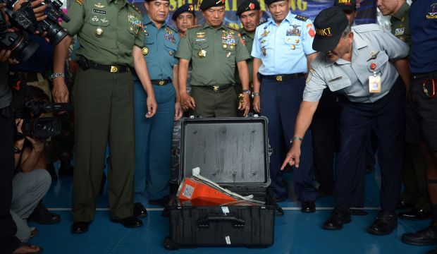 Tatang Kurniadi (R) from The National Transportation Safety Committee (KNKT) gestures next to Indonesian Military Chief General Moeldoko as Indonesian officers looks at the FDR (Flight Data Recorder) (Bottom C) of the AirAsia flight QZ8501 in Pangkalan Bun after it was retrieved from the Java Sea on January 12, 2015. (AFP PHOTO / ADEK BERRY)