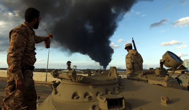 Members of the Libyan army watch black smoke rise from the city's port after a fire broke out at a car tire disposal plant during clashes against Islamist gunmen in Benghazi, on December 23, 2014 (AFP PHOTO / ABDULLAH DOMA)