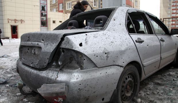 A man stands next to his car destroyed after shelling between Ukrainian army and pro-Russian separatists in the eastern Ukrainian city of Donetsk on January 18, 2015. (AFP PHOTO/ ALEKSANDER GAYUK)