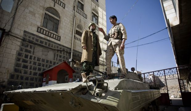 Houthi fighters wearing army uniforms stand atop an armored vehicle, outside the house of Yemen's former president Abd Rabbuh Mansur Hadi in Sana'a, Yemen, on January 22, 2015. (AP Photo/Hani Mohammed)