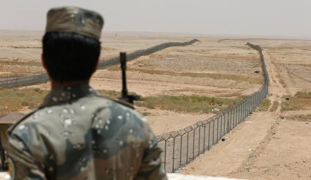 A member of the Saudi border guards force stands guard next to a fence on Saudi Arabia's northern border with Iraq, in this July 14, 2014 file photo.    REUTERS/Faisal Nasser/Files