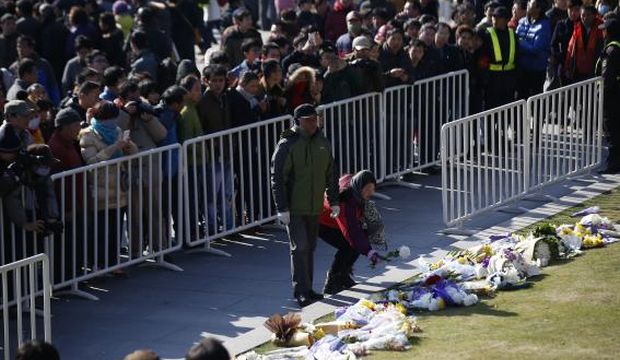 People lay down flowers during a memorial ceremony in memory of people who were killed in a stampede incident during a New Year's celebration on the Bund, in Shanghai, China, on January 1, 2015. (Reuters/Aly Song)