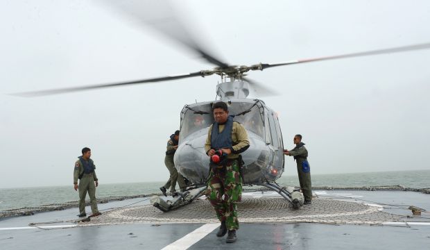 Indonesian officers arrive at an Indonesian Navy vessel KRI Bung Tomo at sea on January 1, 2015. Indonesian searchers promised an "all-out effort"  to locate bodies from AirAsia Flight QZ8501 as international investigators joined the hunt for the ill-fated plane. (AFP Photo/Adek Berry) 