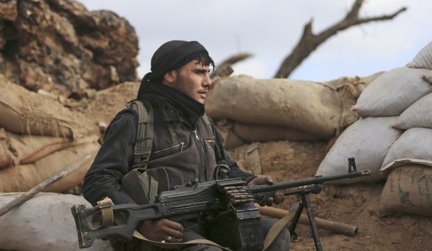 A rebel fighter from the Free Syrian Army's Al-Rahman legion takes up position behind sandbags in Jobar, a suburb of Damascus, on December 22, 2014. (Reuters/Baszsem Khabieh)