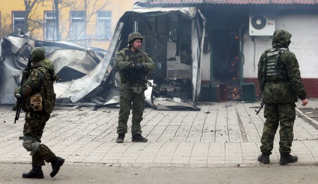 Ukrainian servicemen stand guard near a destroyed shop after shelling in the southern Ukrainian port city of Mariupol on 24, 2015. (AFP Photo) 