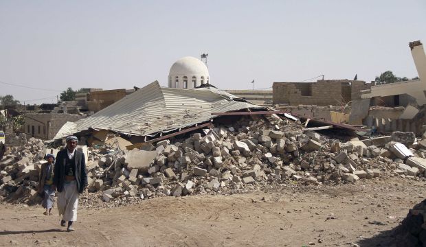 People walk past debris of a building in Arhab, north of Sana'a, that was reportedly bombed by Houthi militants, on January 13, 2015. (Reuters/Stringer)