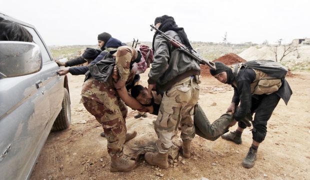 Fighters from Suqour Al-Sham Brigade, which is part of the Free Syrian Army, carry a wounded member of their brigade during what activists said were clashes with Syrian government forces, in the Al-Arbaeen mountain area of western Idlib on January 30, 2015. (REUTERS/Khalil Ashawi)