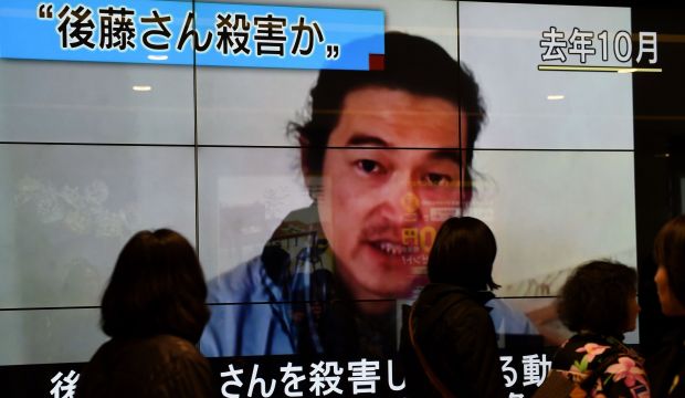 People walk past a big screen reporting that a Japanese hostage was killed by the ISIS, in Tokyo, Japan, on February 1, 2015. (AFP PHOTO / Toru YAMANAKA)