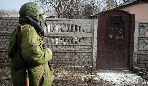 A pro-Russian rebel looks at the door of a house, with "There are people" written on it, in the eastern Ukrainian town of Vuglegirsk in the Donetsk region, on on February 7, 2015 (AFP PHOTO/ ANDREY BORODULIN)