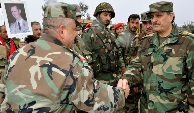 A picture released by the official Syrian Arab News Agency on February 12, 2015 shows Syria's Gen. Fahd Jassem Al-Freij (R) shaking hands with a soldier as he visits a military unit at an undisclosed location in southern Syria. (AFP Photo/HO/SANA)