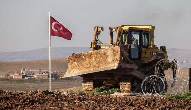 A picture made available on February 23, 2015 shows a digger working near a Turkish flag at the new site for the tomb of Suleyman Shah, near the Esme region in Syria, on February 22, 2015. (EPA/Mursel Coban/Depo Photos)