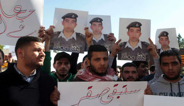 Jordanian students hold a sign reading in Arabic, 'You will stay a Falcon' and pictures of Muath al-Kassasbeh, the Jordanian pilot being held by ISIS in Syria, during a support rally at Jordan University, Amman in Amman on 3  February, 2015. (EPA)