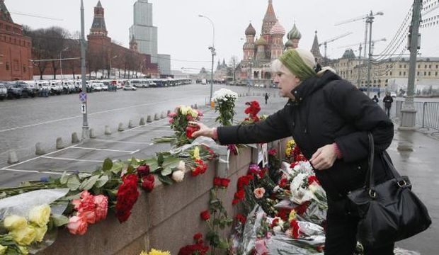 A woman places a candle at the site of the killing of Russian opposition veteran leader Boris Nemtsov in central Moscow, Russia, on March 1, 2015. (EPA/Sergei Ilnitsky)