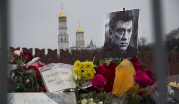 Flowers and a condolence message that reads "In memory of Boris" are placed with a portrait of Boris Nemtsov at the site where Nemtsov was gunned down near the Kremlin, against a backdrop of the Kremlin Wall, in Moscow, Russia, Monday, March 2, 2015. (AP Photo/Ivan Sekretarev)