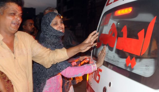 Pakistani relatives mourn beside an ambulance carrying the body of convicted murderer Muhammad Faisal after his execution in Karachi on March 17, 2015. (AFP Photo/Rizwan Tabassum)