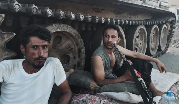 Members of a militia loyal to Yemen's President Hadi chew qat as they sit next to their tank, guarding a major intersection in Aden, Yemen, on March 21, 2015. (AP Photo/Hamza Hendawi, File)