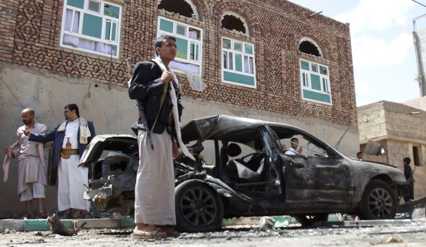 Houthi fighters stand near a damaged car after a suicide attack on a mosque in Sana'a, Yemen, on March 20, 2015.  (AP Photo/Hani Mohammed)